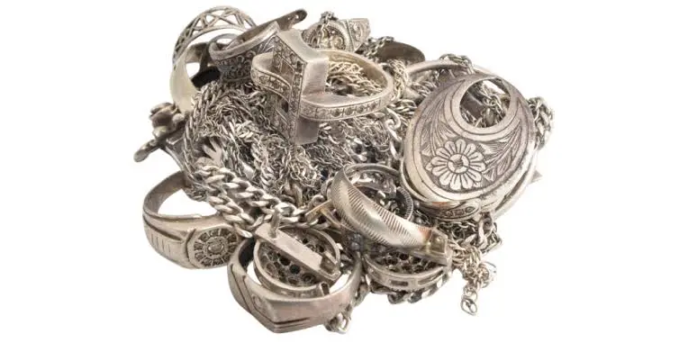 Pile of sterling silver rings, chains and a locket ready to sell.